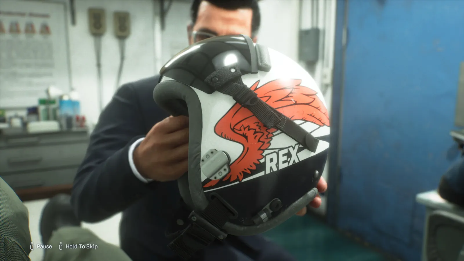 A crew member holding a flight helmet marked REX
